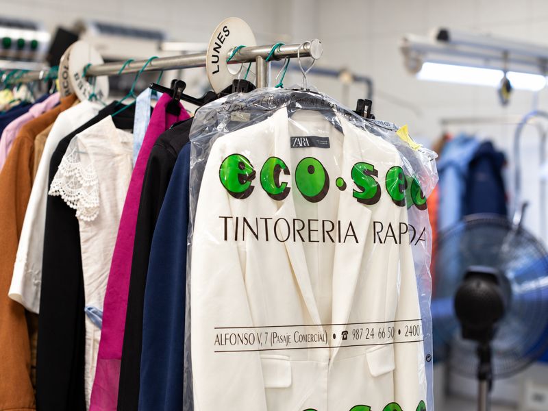 Prendas limpias en fundas de eco·sec colgadas en el perchero